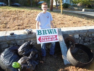 Cleanup volunteer with sign.