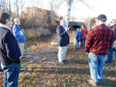 Gene Bernat speaking to group on the bank of the canal