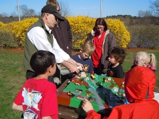 Peter Coffin of the
            Blackstone River Coalition demonstrates a watershed model to EarthDay
            Cleanup Volunteers during the Clean and Green Fair at River Bend Farm.